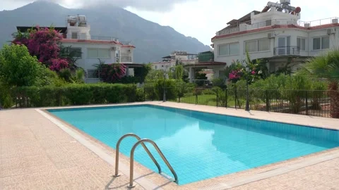 Beautiful rectangular outdoor pool with blue turquoise water and a villa Stock Footage 134614113