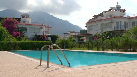 Beautiful rectangular outdoor pool with blue turquoise water and a villa Vidéo 134614273