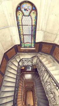Beautiful rectangular spiral staircase with black railings and amazing staine Stock Photos