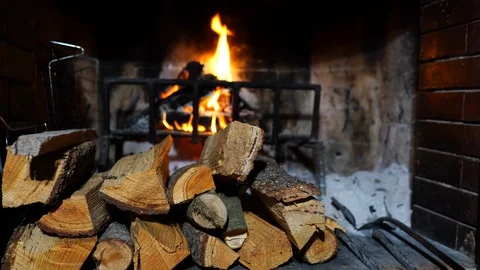 Beautiful red brick fireplace full of wooden brunches burning at home Stock Footage 110701080