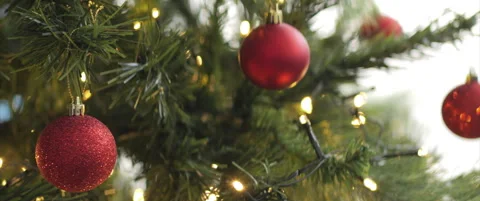 Beautiful red Christmas baubles on lighted tree 4K scope video Stock Footage 324026862