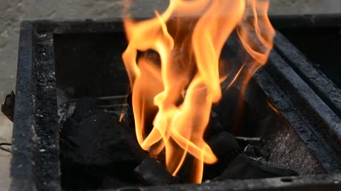 Beautiful red fire from dark grey black coals inside metal brazier.  Vídeos de archivo 130372462