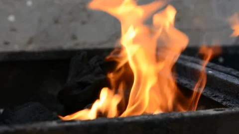 Beautiful red fire from dark grey black coals inside metal brazier.  Vídeos de archivo 130372472