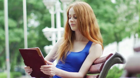 Beautiful, red-haired woman using a tablet in the city Stock Footage 50444060