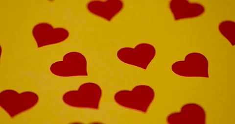 Beautiful red hearts made of plastic and film pasted on yellow paper, red Stock Footage 324879730