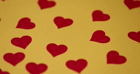 Beautiful red hearts made of plastic pasted on yellow paper, red symmetrical Stock Footage 326368507