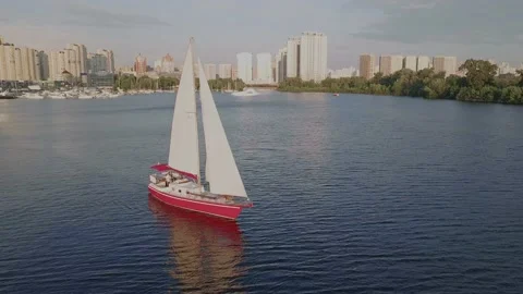 Beautiful red ship with open sails on the river in front of the city. Aerial Stock Footage 171684013