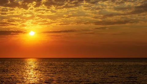 Beautiful red sunset, dark clouds and ocean on the horizon Stock Photos