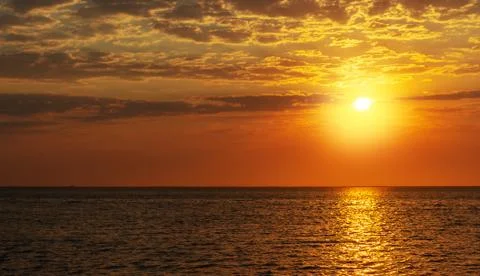 Beautiful red sunset, dark clouds and ocean on the horizon Stock Photos