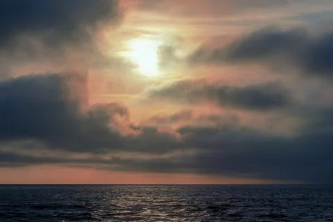 Beautiful red sunset, dark clouds and atlantic ocean on the horizon Stock Photos
