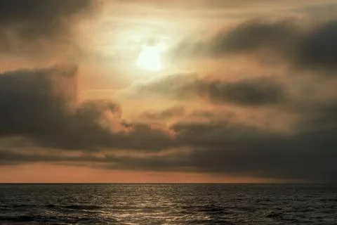 Beautiful red sunset, dark clouds and atlantic ocean on the horizon Stock Photos
