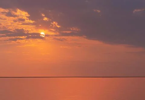 Beautiful red sunset, dark clouds and atlantic ocean on the horizon Stock Photos