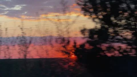 Beautiful red sunset seen from a moving car window Vidéo 340237972