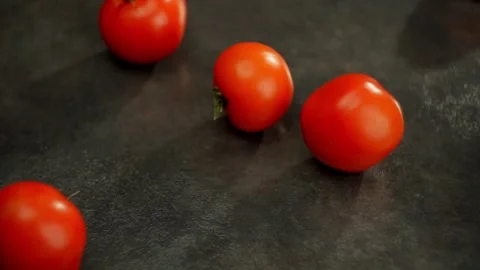 Beautiful red tomatoes roll into the frame on the table. Stock Footage 270738937