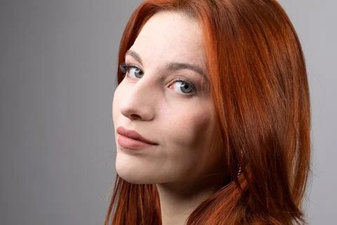 Beautiful redhead model posing on a grey background Fotos de archivo