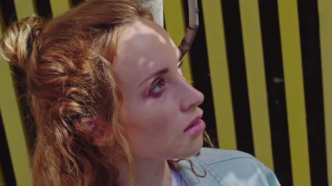 Beautiful redhead relaxing in the shade of a tree. Side view. Slow motion. Stock Footage 160550048