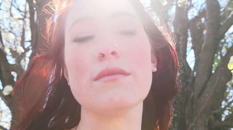 Beautiful Redhead by a tree in a park Stock Footage 50946720