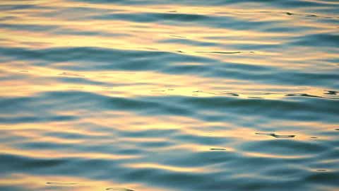 Beautiful reflection golden sun light on blue water, rippled waves. 库存影片 264034409