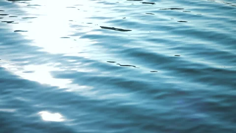 Beautiful reflection white sun light on blue water, rippled waves. 스톡 동영상 264034128