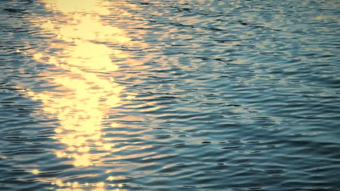 Beautiful reflection yellow sunset light on blue water, rippled waves. Stock Footage 251427286