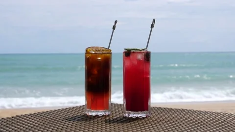 Beautiful Refreshing Fruit Cocktails on Table on Beach, Blue Sea on Background Stock Footage 157447096