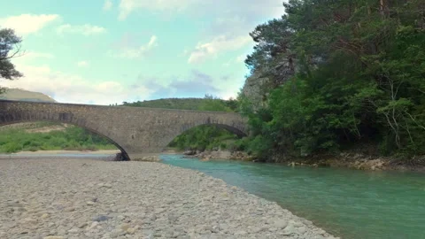 A beautiful river flows under a stone bridge in French Provence. Stock Footage 113461535
