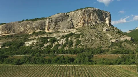 A beautiful road among the fields, valley, rocky ridges, hills and mountains. Stock Footage 165496764