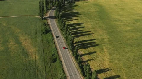 A beautiful road among the fields, valley, rocky ridges, hills and mountains. Stock Footage 165496790