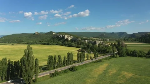 A beautiful road among the fields, valley, rocky ridges, hills and mountains. Stock Footage 165496802