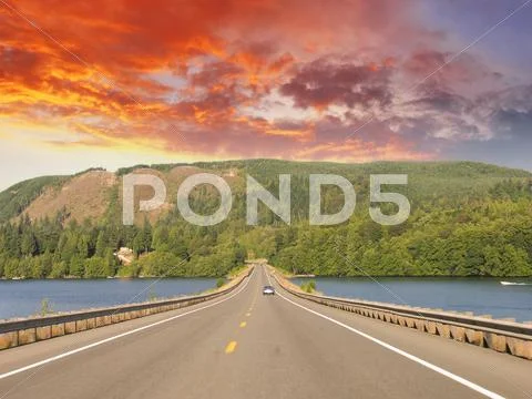 Beautiful road on the lake with sunset colors Stock Photos