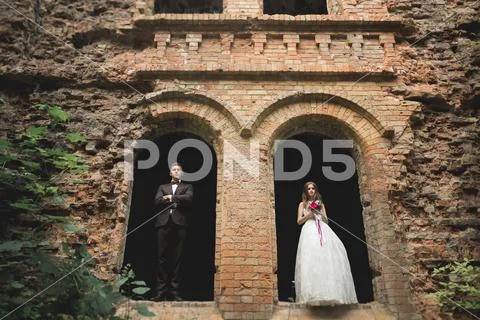 Beautiful Romantic Wedding Couple Of Newlyweds Hugging Near Old