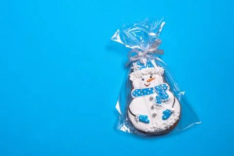 Beautiful round gingerbread cookie in the shape of a snowman on a blue backgr Stock Photos