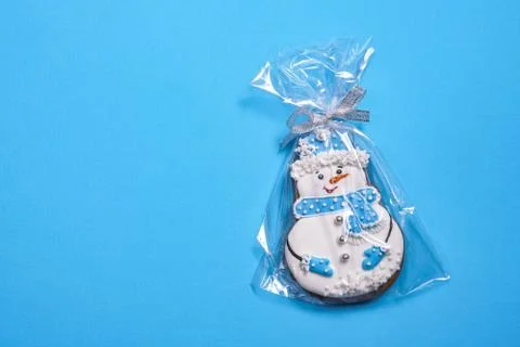 Beautiful round gingerbread cookie in the shape of a snowman on a blue backgr Stock Photos