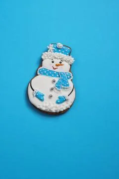 Beautiful round gingerbread cookie in the shape of a snowman on a blue backgr Stock Photos