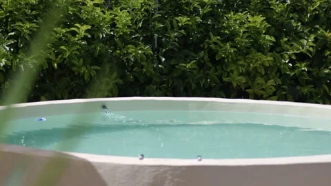 Beautiful round pool surrounded by green countryside Stock Footage 141333089