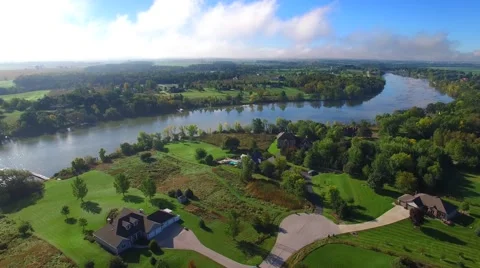 Beautiful rural homes line the shores of scenic river in autumn Stock Footage