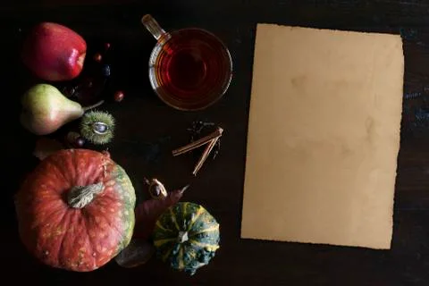 Beautiful rustic fall flat lay with glass of tea, leaves, pumpkins, chestnuts Stock Photos