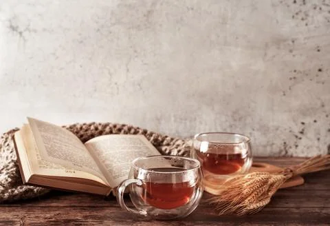 Beautiful rustic template of two cups of tea and book on wooden background. Cozy Stock Photos