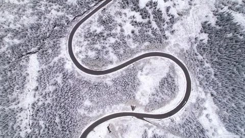 Beautiful S-shaped bend of winter road through hills and forest in mountains Stock Footage 257299915