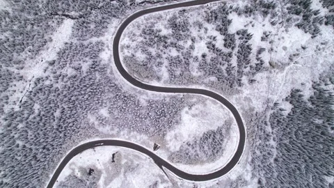 Beautiful S-shaped bend of winter road through hills and forest in mountains Stock Footage 257299927