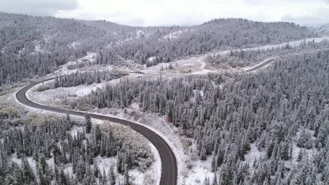Beautiful S-shaped bend of winter road through hills and forest in mountains Stock Footage 257299960
