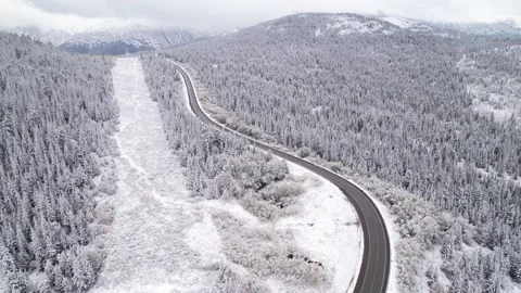 Beautiful S-shaped bend of winter road through hills and forest in mountains Stock Footage 257300006