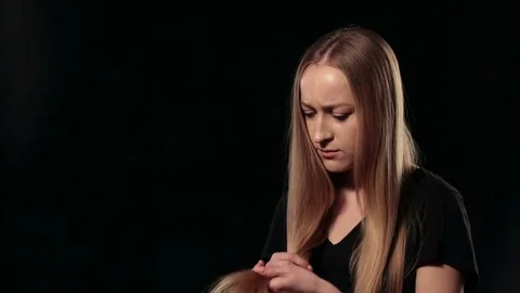 Beautiful sad woman holding split ends of her hair Stock Footage