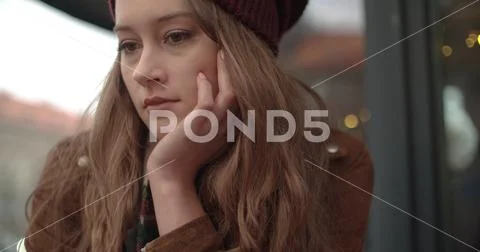Beautiful sad woman sitting alone in outdoors restaurant. Stock Photos