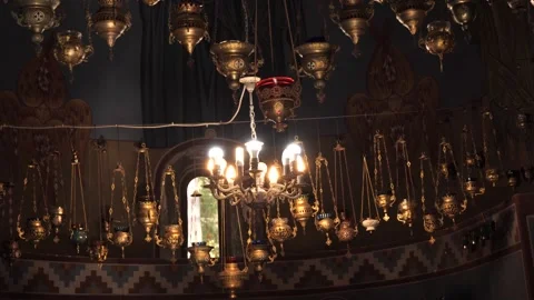 Beautiful sanctuary lamps dangle from the ceiling in a historic church. Видео 285153249