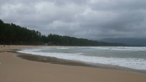 Beautiful sand beach with soft wave in sea water , cloudy rainy sky , mountai Stock Footage 94499622