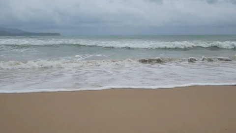 Beautiful sand beach with soft wave in sea water , cloudy rainy sky. Stock Footage 94506522