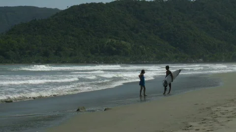 Beautiful sand beach with waves rolling in slowly and a couple in the distance  Video stock 609114