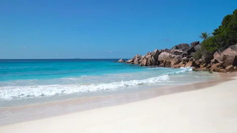 Beautiful sandy beach with blue sky and ocean waves on an exotic island Stock Footage 106370433