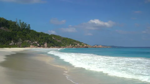 Beautiful sandy beach with blue sky and ocean waves on an exotic island Stock Footage 107510076